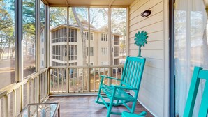 Une véranda avec un plancher en bois et une chaise turquoise.