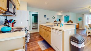 Une cuisine avec des meubles de rangement en bois, une cuisinière, un évier et un lave-vaisselle.