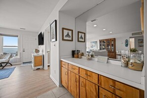 Una cucina moderna con mobili in legno, un grande specchio e oggetti decorativi.