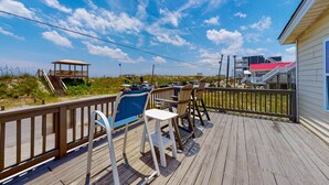 A wooden deck with outdoor seating, a beach view, and a lifeguard tower. - Oceanview home with direct beach access just across the street (Surf City)