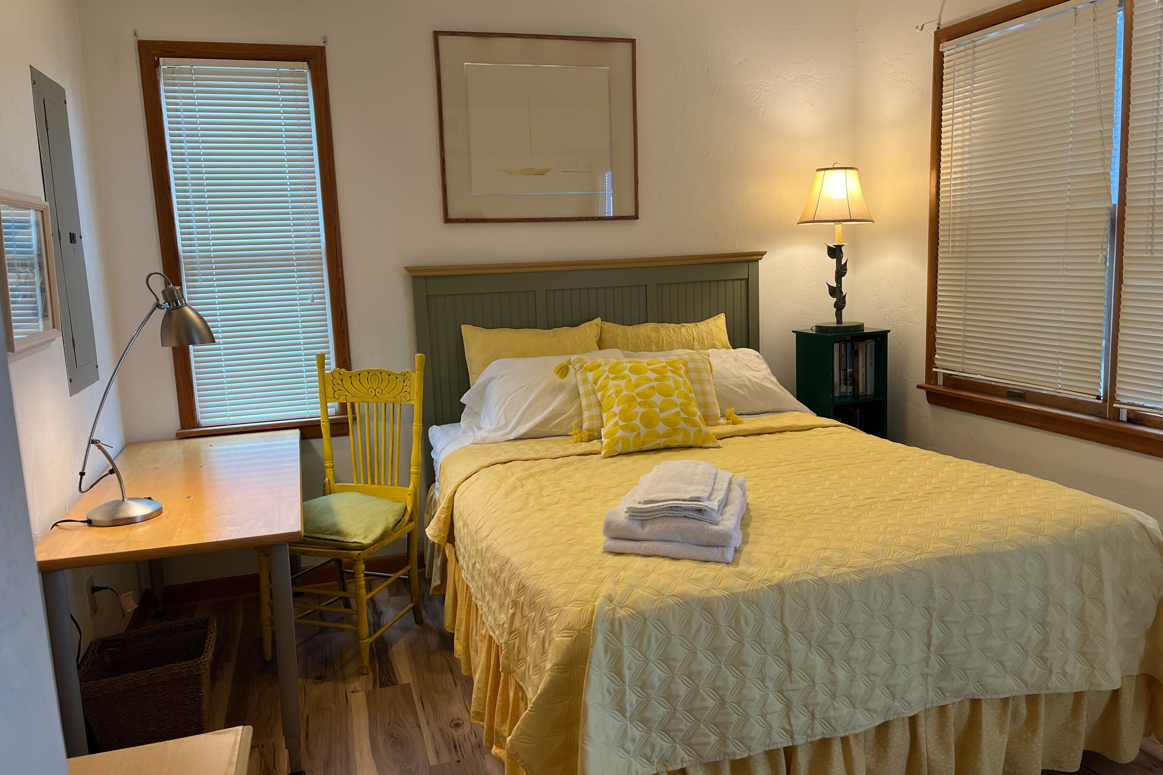 A neatly arranged bedroom with a bed, a desk, and a chair.