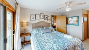 A bedroom with a bed, a nightstand, a ceiling fan, and framed pictures on the wall. - Oceanfront, Dog-Friendly House w/ Free WiFi, Central AC, Private W/D, Ocean View (Hatteras)