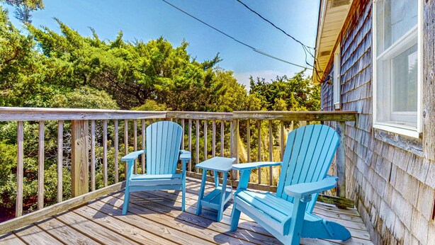 A wooden deck with two blue Adirondack chairs and a small table. - Charming Family Getaway in Salvo with A/C, Full Kitchen, and Gas Grill (Salvo)