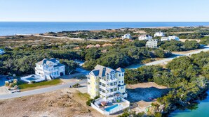 A coastal residential area with multiple houses, a large building with a pool, and a view of the ocean. - Lakefront, dog-friendly home with W/D, private pool & hot tub - close to beach (Avon)