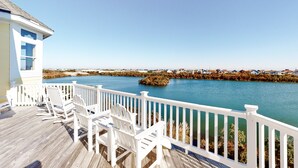 A wooden deck with white railings and chairs overlooking a body of water with a distant shoreline. - Lakefront, dog-friendly home with W/D, private pool & hot tub - close to beach (Avon)
