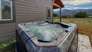 A hot tub outside a house with a wooden deck and a view of mountains. - Elkmont Mountain Splash • Indoor Pool & Views (Sevierville)
