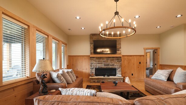 A cozy living room with leather sofas, a fireplace, and a large TV. - Elkmont Mountain Splash • Indoor Pool & Views (Sevierville)