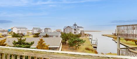 A residential area with houses, a wooden dock, and a clear view of the water.