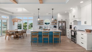 Una cocina moderna con una isla central, sillas de madera y armarios empotrados.