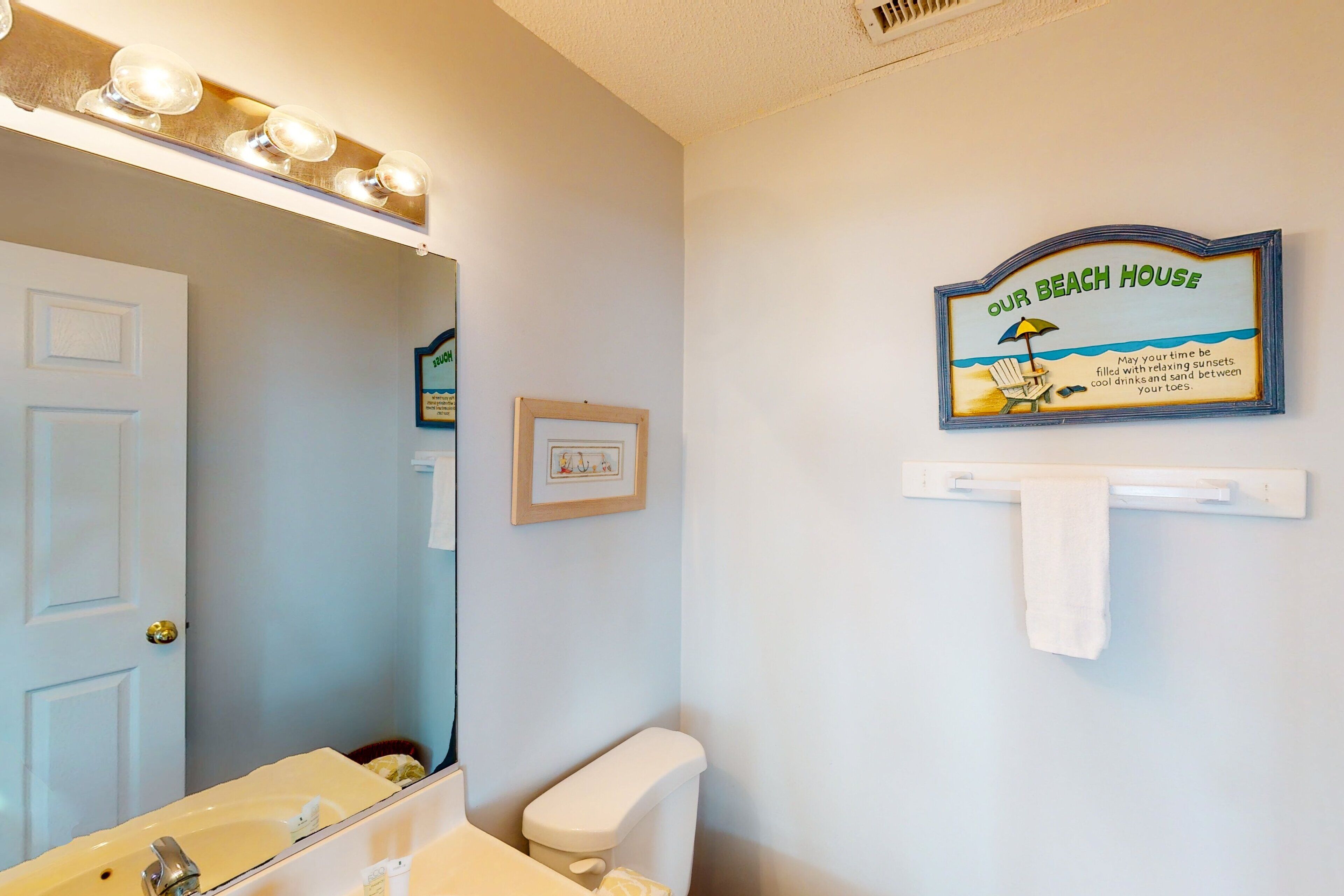 A bathroom with a sink, mirror, and a towel rack.