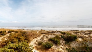 A beach with a pier extending into the ocean. - Oceanfront home with incredible beach views, washer/dryer & pool (Avon)