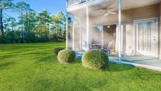 Ein zweistöckiges Haus mit einer Veranda und einem Essbereich, mit einem sichtbaren Deckenventilator.