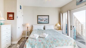 Una camera da letto con un letto, due comodini, un tavolino e una finestra con tende.
