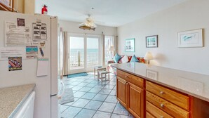 Una cucina con frigorifero, mobili in legno e vista all'esterno.
