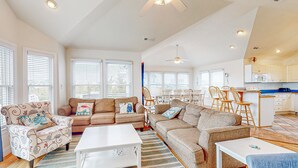 A spacious living area with a sofa set, a coffee table, and a dining area with chairs and a kitchen in the background. - Dog-friendly lakefront home with private pool, hot tub, & tennis (Avon)