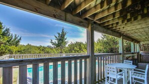 A covered outdoor area with a wooden deck, a pool, and outdoor furniture. - Dog-friendly lakefront home with private pool, hot tub, & tennis (Avon)