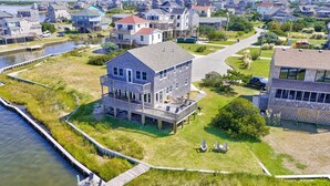 A waterfront property with a large house featuring a deck and multiple levels. - Sound FX 437: Sound-front w/shared pool (Avon)