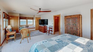 A bedroom with a bed, a television, a desk, and a chair. - Sound FX 437: Sound-front w/shared pool (Avon)