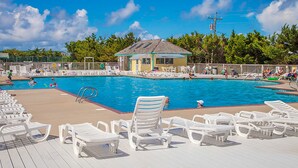 A swimming pool with lounge chairs, a small building, and trees in the background. - Sound FX 437: Sound-front w/shared pool (Avon)