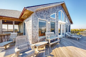 A wooden deck with outdoor seating and large windows. - Rogue Wave 146: Ocean and sound views, beach access, private hot tub (Avon)