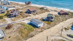 Uma área residencial costeira com casas, uma praia e vista clara do oceano.