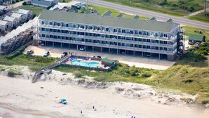 Un grand hôtel avec de nombreux étages, une piscine et un espace de plage.