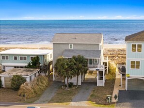 A coastal property with a beach view, a two-story house, and a smaller building. - Barefeet Retreat: Oceanfront home with a Private Beach Access and Spacious Covered Porches (Holden Beach)