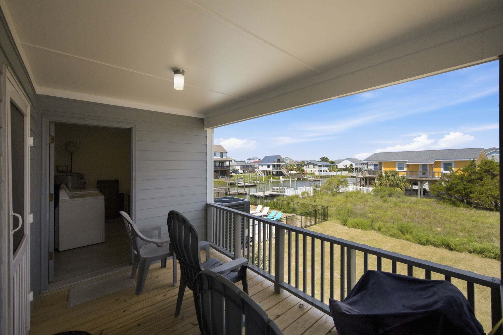 A covered outdoor area with a view of a marina and houses.
