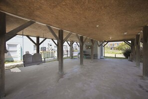 An open, unfinished interior space with concrete flooring and exposed wooden beams.