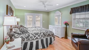 Een slaapkamer met een bed, een dressoir, een kaptafel en een stoel.