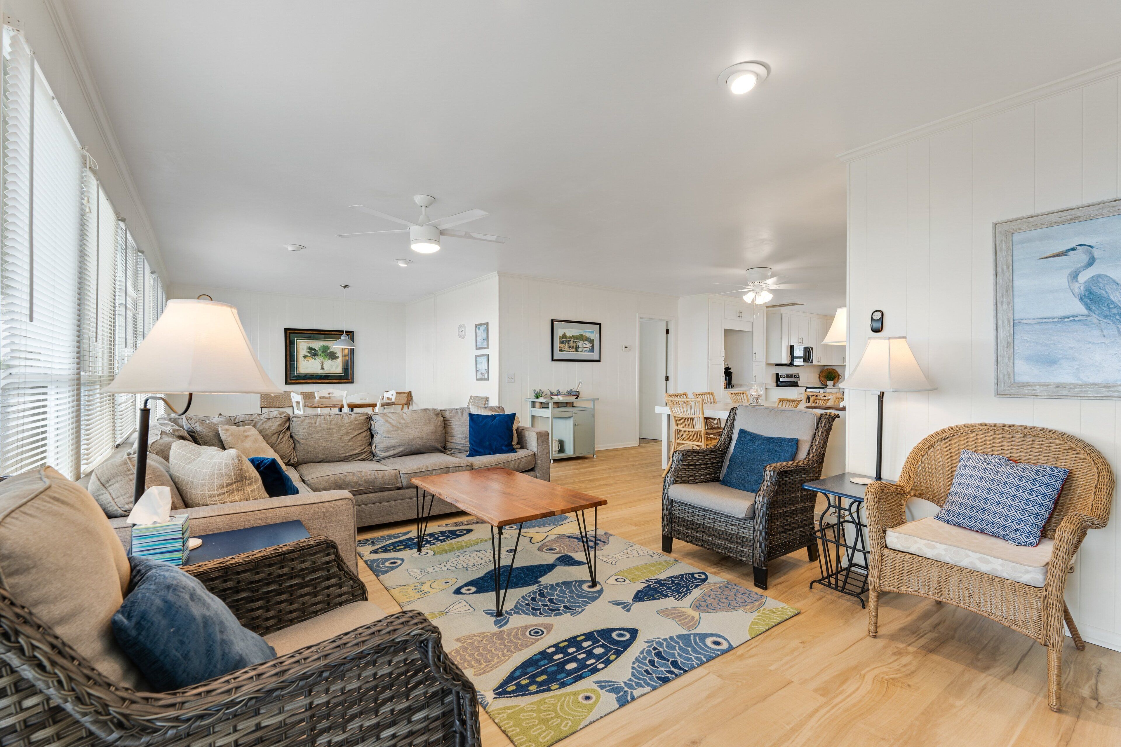 A spacious living room with a sofa, chairs, a coffee table, and a dining area.