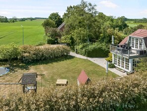 A house with a large deck, a swimming pool, and a well-maintained lawn. - 5 Star Holiday Home in Otterup (Otterup)