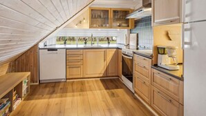 Een moderne keuken met houten kastjes, een inbouwoven en een vaatwasser.