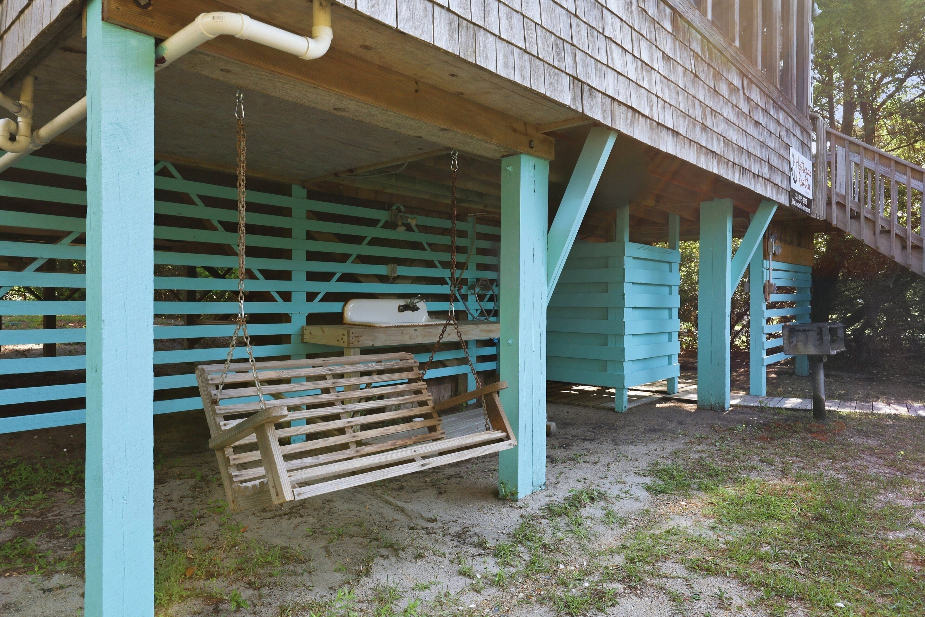 A wooden structure with a porch, a swing, and a mailbox.