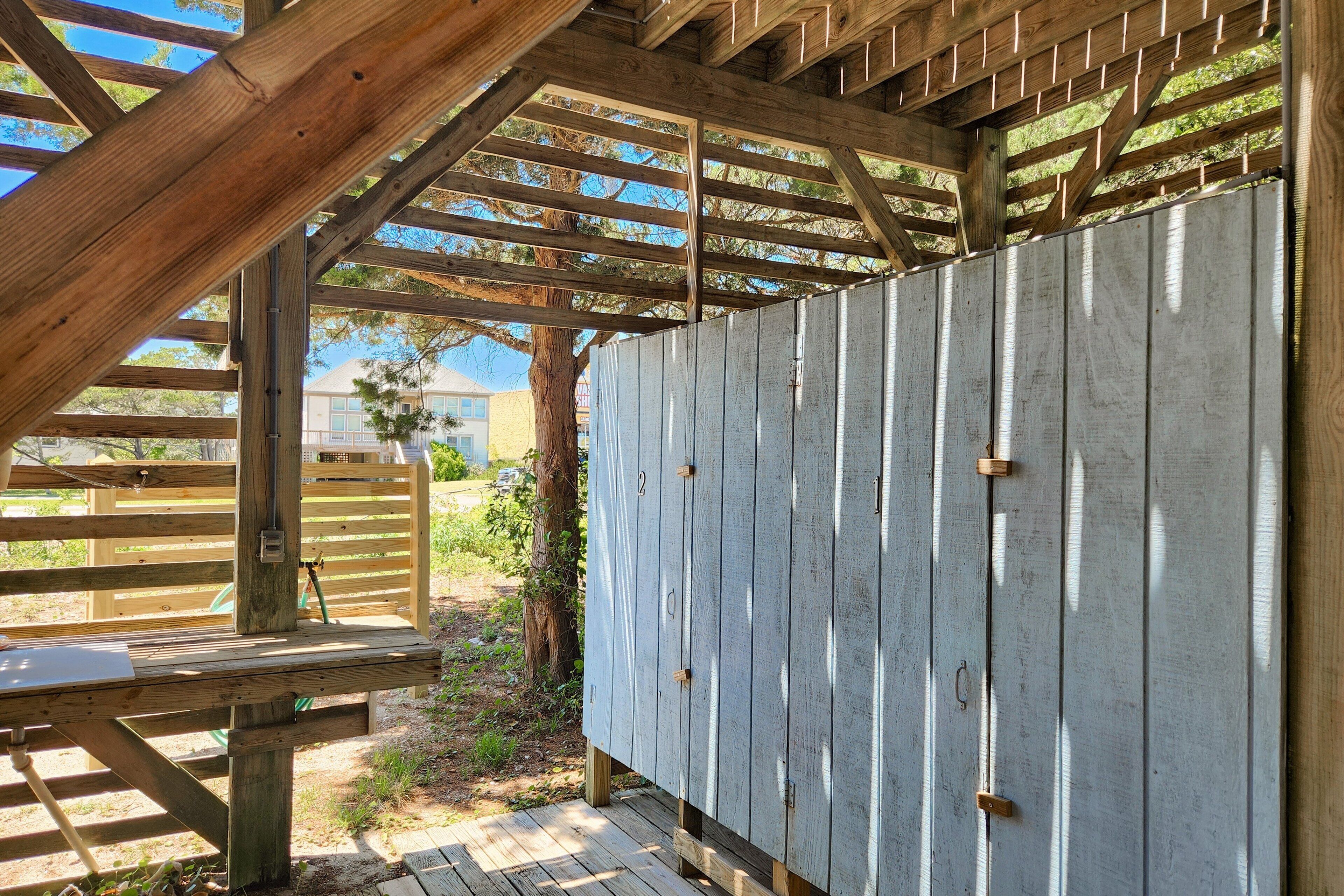Une structure de pergola en bois, agrémentée d’une clôture en métal, d’un banc en bois et offrant une vue dégagée sur les environs.