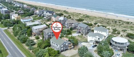 Ein Luftbild eines Küstenwohngebiets mit Häusern, einem Strand und einer Straße.