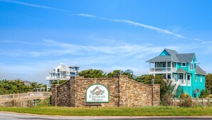 A coastal property with a prominent sign reading "Kinnakeet Shores." - Carolina Breeze 488: Nature lover's home, sound-front with great views, shared pool (Avon)