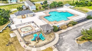 An aerial view of a residential area with a swimming pool, a playground, and a covered patio area. - Carolina Breeze 488: Nature lover's home, sound-front with great views, shared pool (Avon)