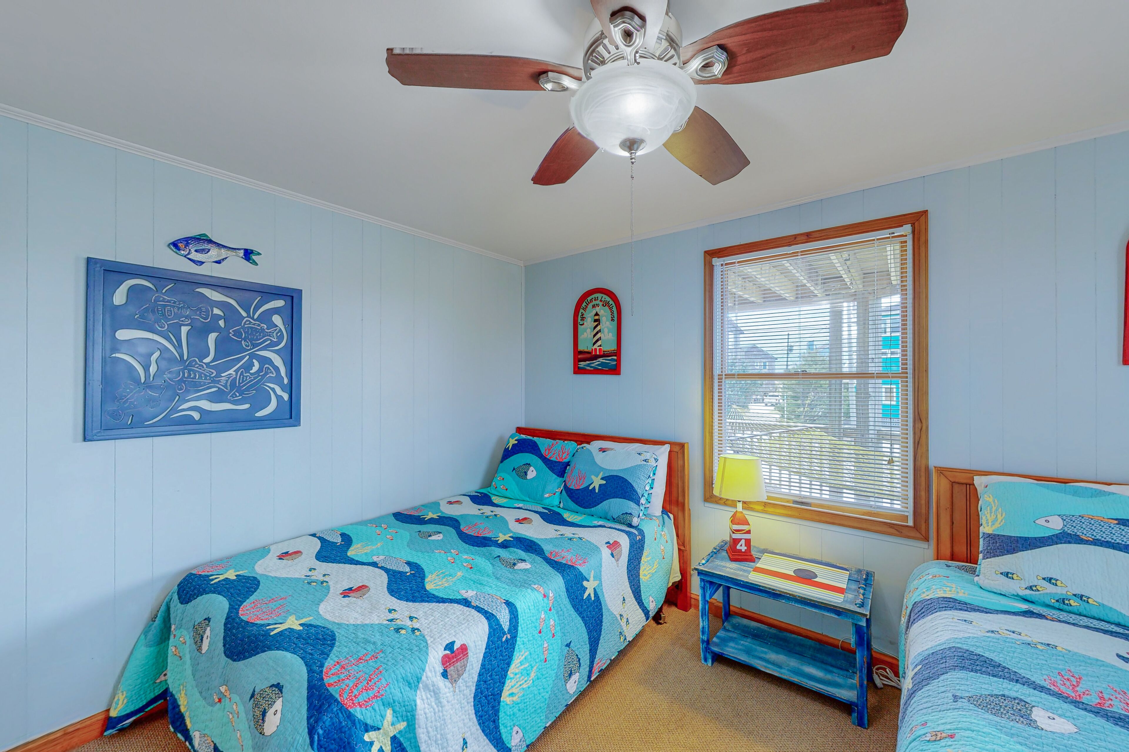 A bedroom with a bed, a nightstand, a ceiling fan, and a window with blinds.
