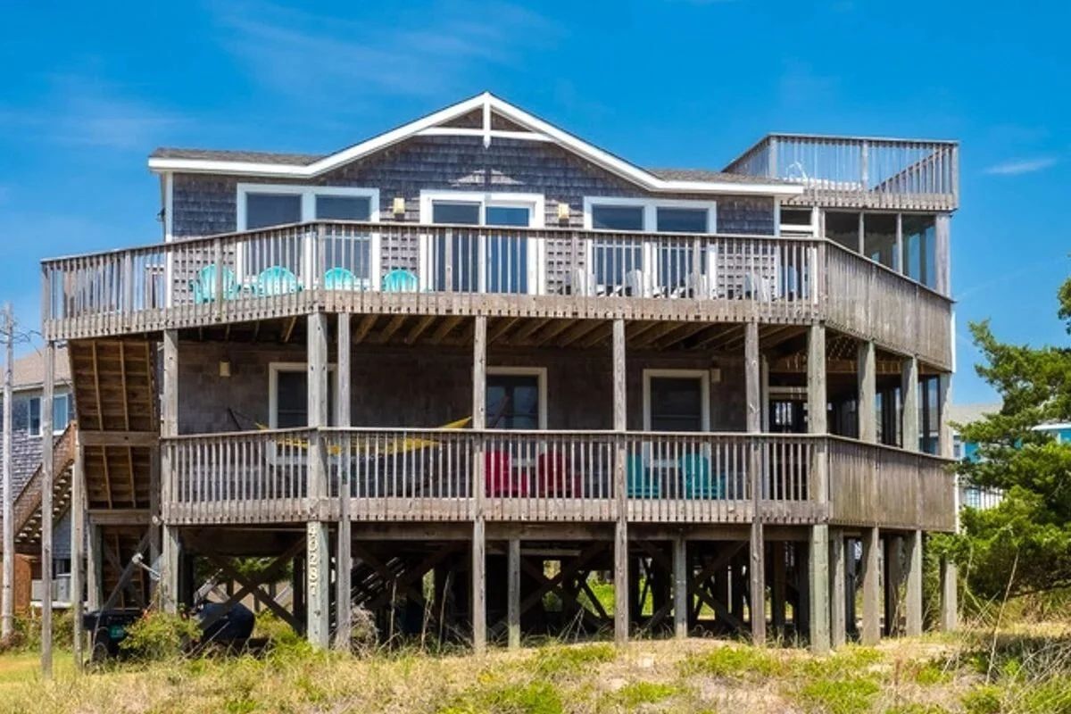 A multi-story building with a balcony on the ground floor.