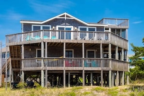 A multi-story building with a balcony on the ground floor. - Dancing Dolphin 106: Dog-friendly,ocean view,hot tub (Avon)