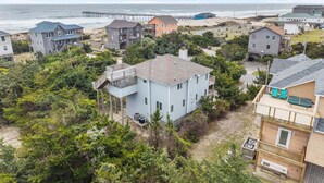 A coastal residential area with houses, a pier, and a beach. - Ocean-view home with pool, private hot tub, W/D - near the beach (Avon)
