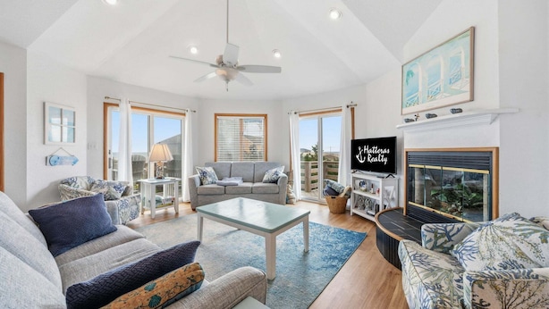 A spacious living room with a sofa, a coffee table, and a fireplace. - Ocean-view home with pool, private hot tub, W/D - near the beach (Avon)