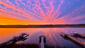 A calm lake at sunset with docks and boats. - Intracoastal Indulgence: Waterfront, pool, dock and water views! (Holden Beach)