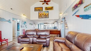 A spacious living room with leather sofas, a wooden coffee table, and artwork on the walls.
