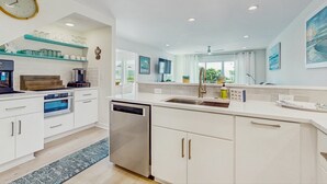 A modern kitchen with white cabinetry, a stainless steel dishwasher, and a built-in oven.