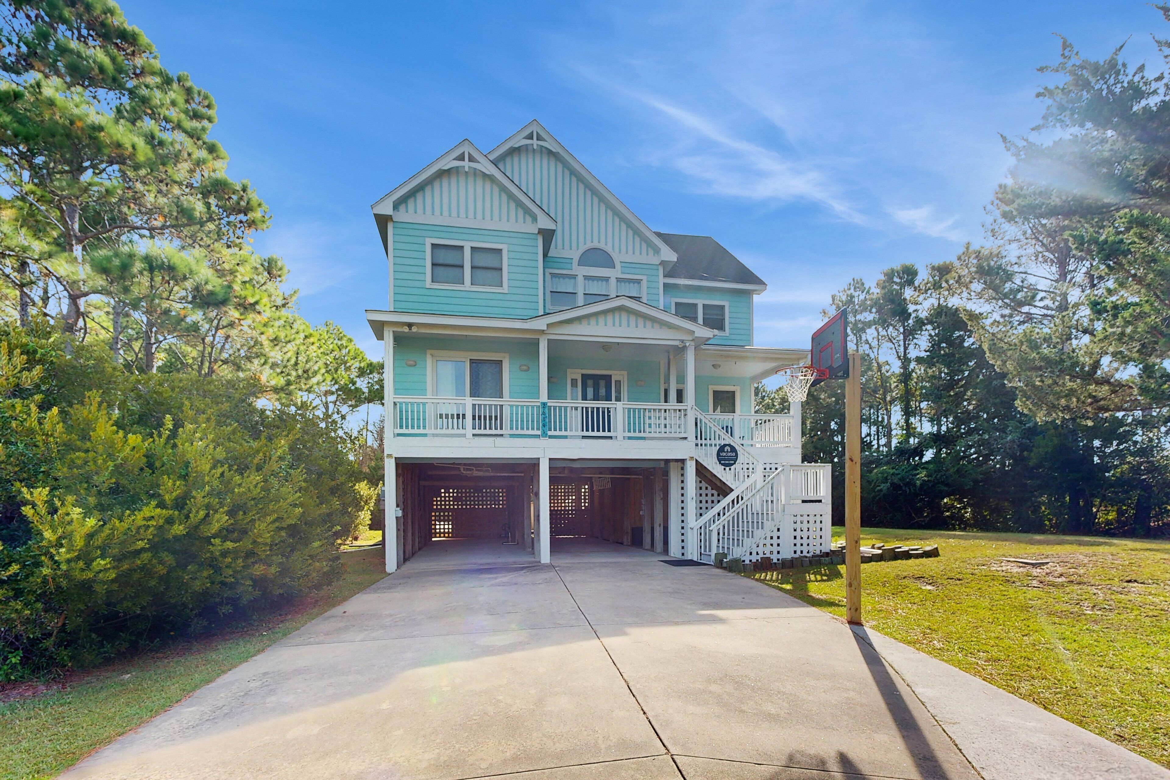 A two-story house with a front porch, a garage, and a basketball hoop.