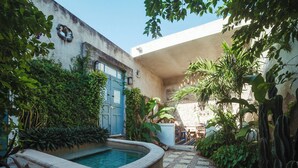 A courtyard with a pool, a blue door, and various plants. - Casa Santorini: elegant stay next to La Ermita (Mérida)