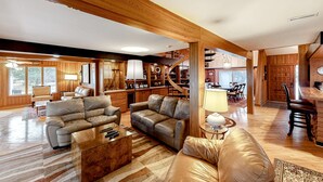 A spacious living room with leather sofas, a coffee table, and a staircase leading to another level. - Exquisite home with private hot tub, game room, & central AC (Salvo)