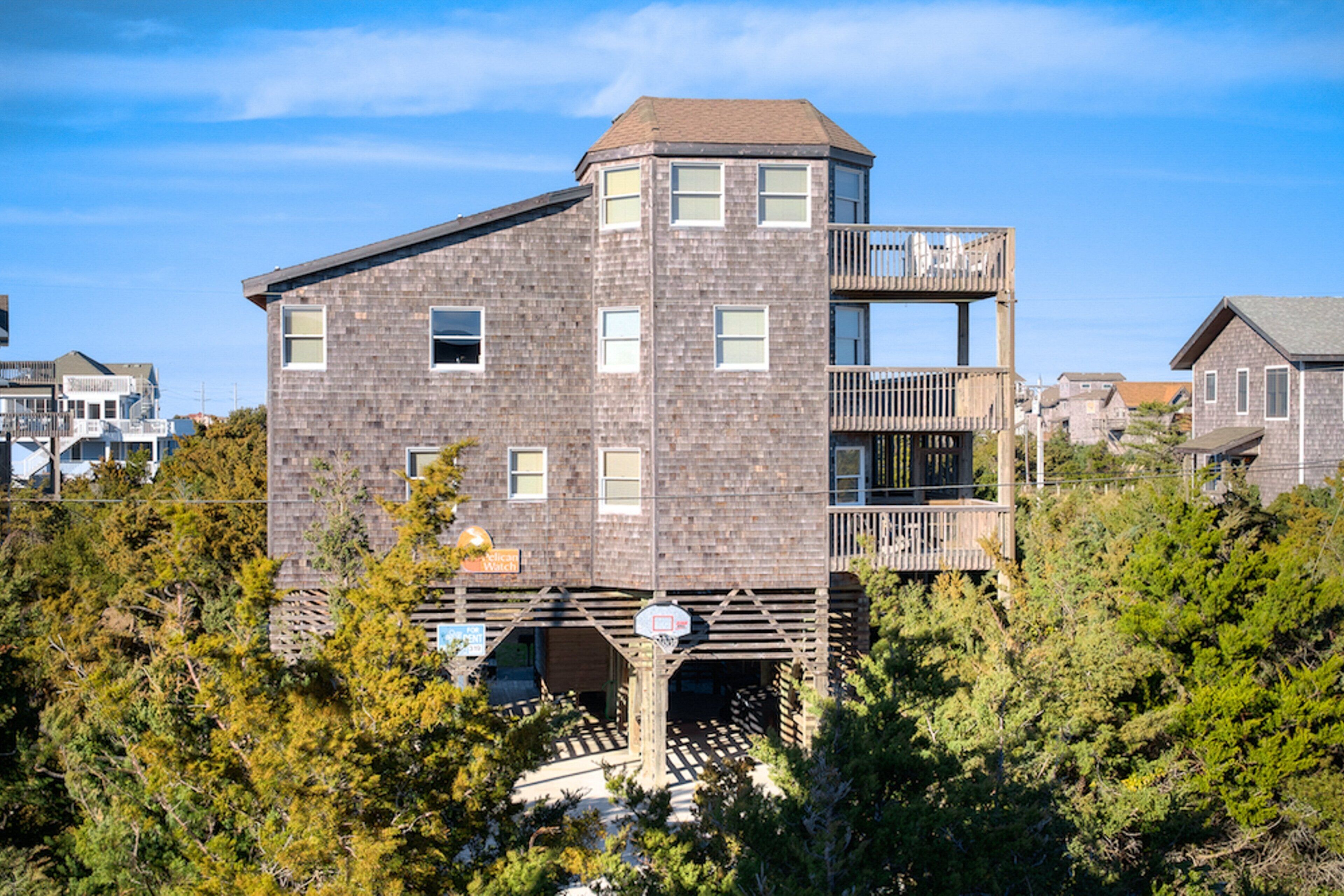A multi-story building with a brick facade, a balcony on the upper floor, and a wooden deck area.